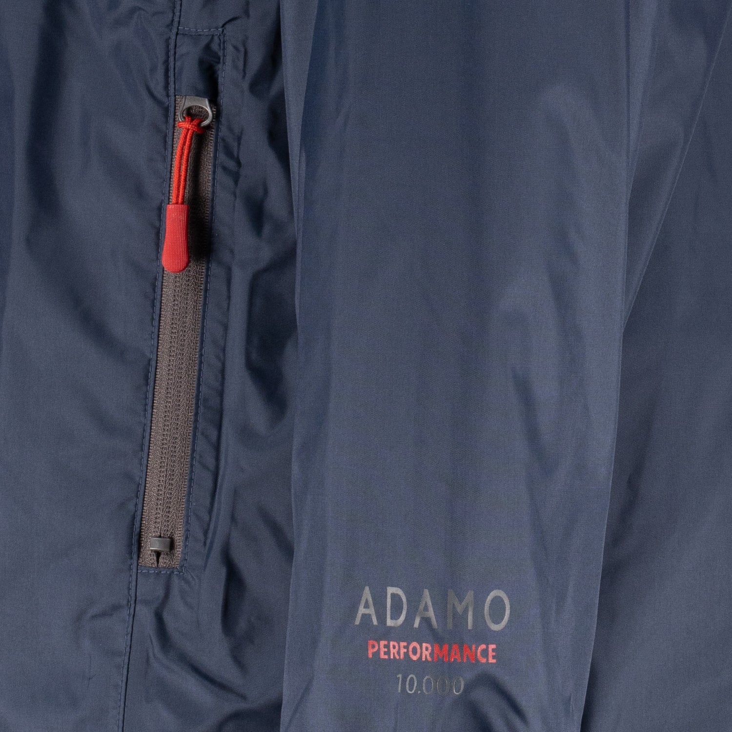 Detailansicht der ADAMO Übergrößen Herren-Regenjacke in Dunkelblau, Reißverschlusstasche und Performance-Logo